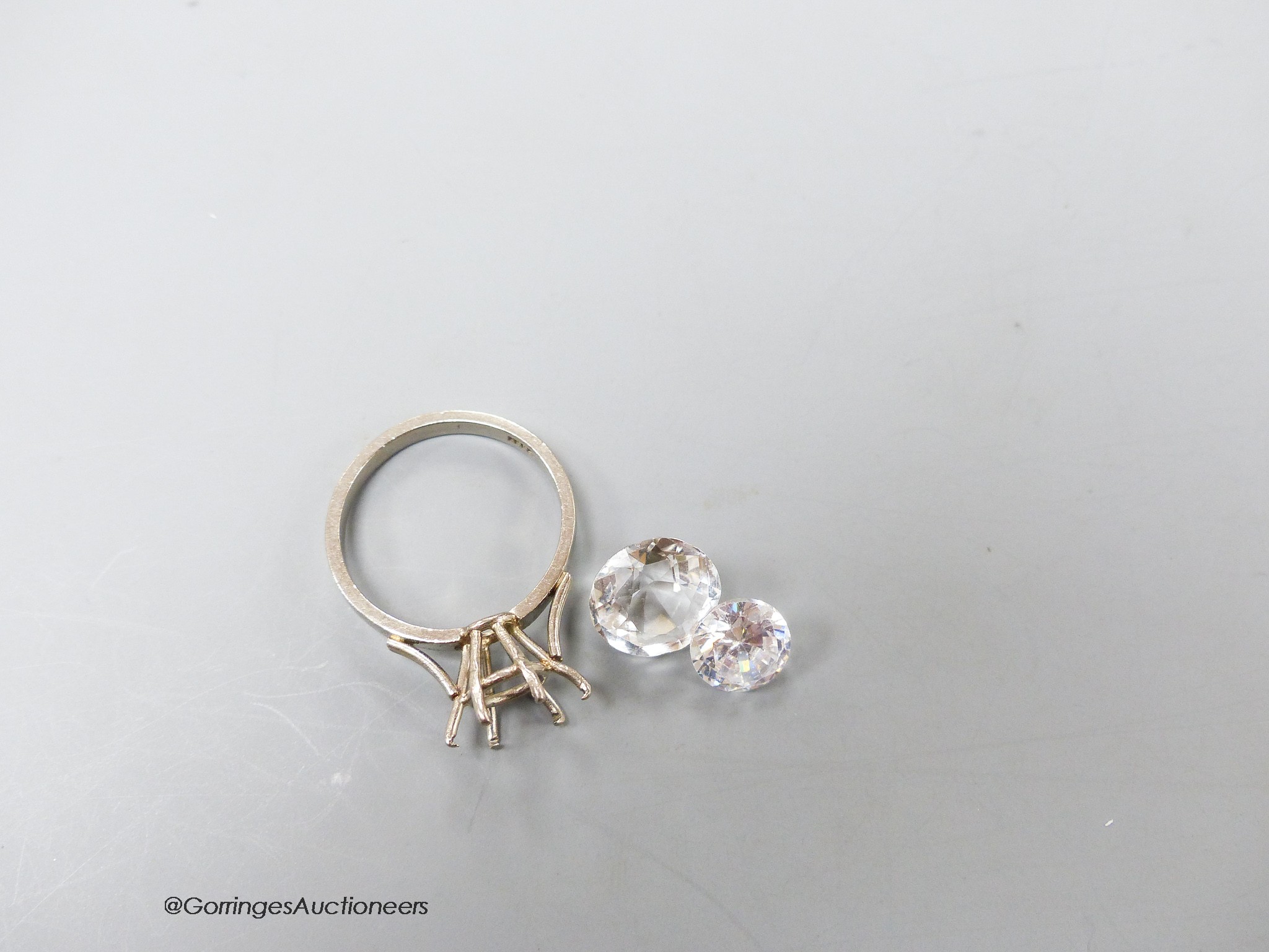 A white metal (stamped 18ct) ring mount, 4.1 grams and two unmounted white paste stones.